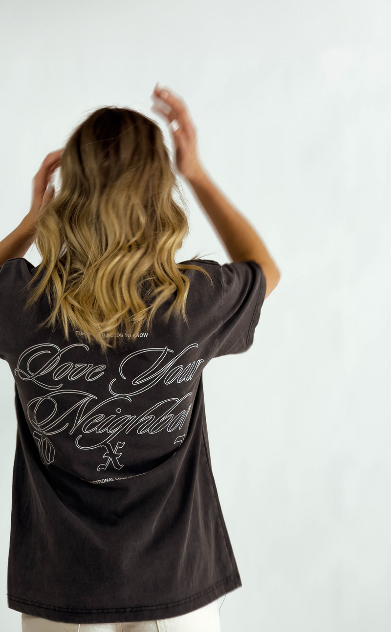 Person wearing a black t-shirt with text on the back against a white background