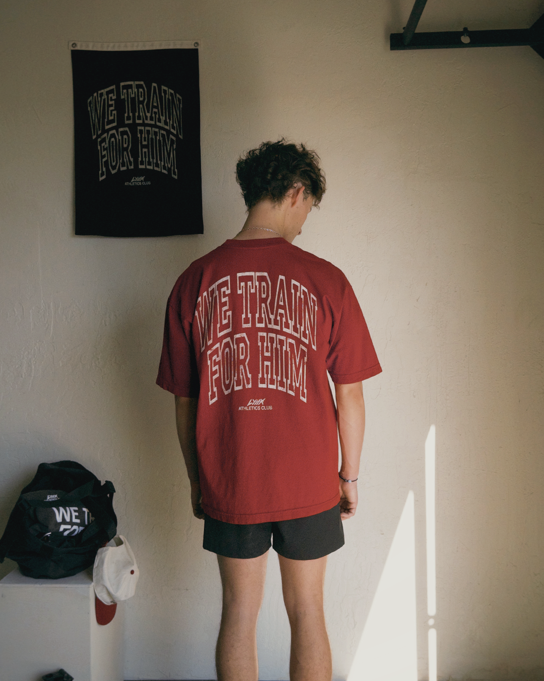 person wearing we train for him tee in gym